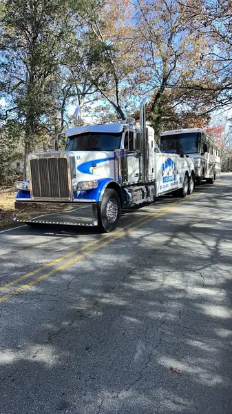 Randy's Towing wrecker towing bus on road