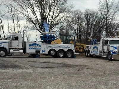 Randy's Towing fleet in yard with construction equipment
