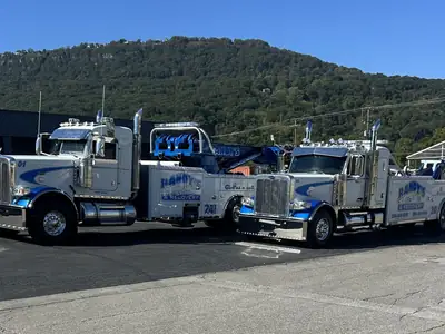 Two Randy's Towing wreckers with mountain backdrop